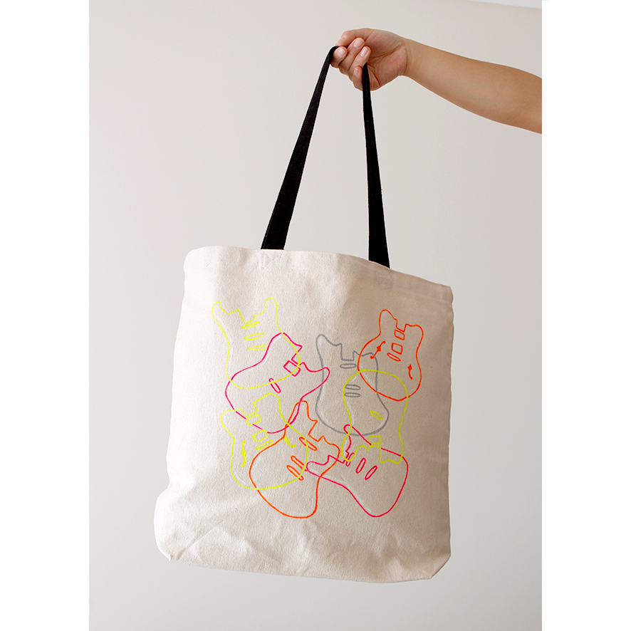 Neon hand-painted guitars overlapping in an abstract way, on a cotton canvas bag with black handles