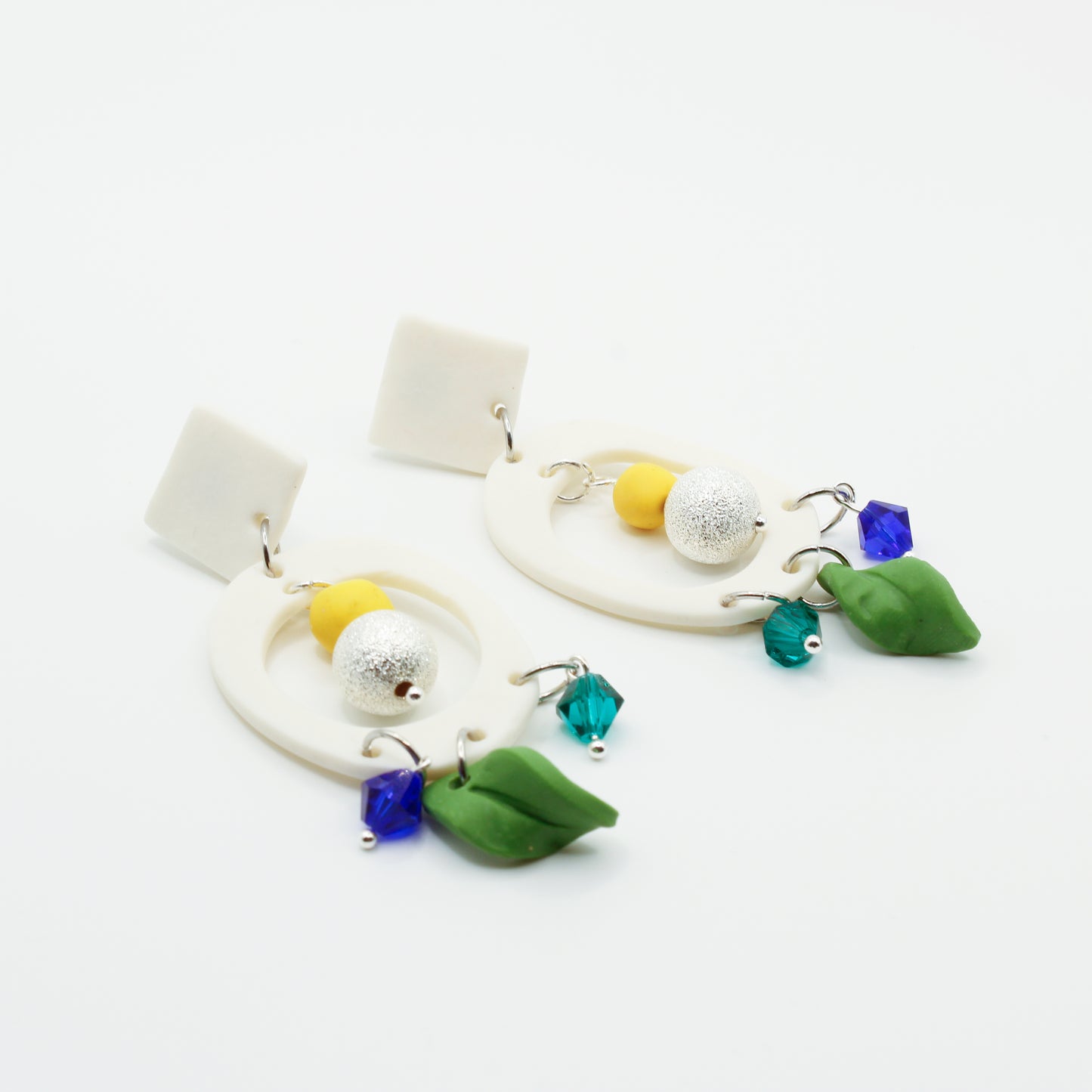 White circle earrings with textured sterling silver beads, crystal glass and polymer clay charms.