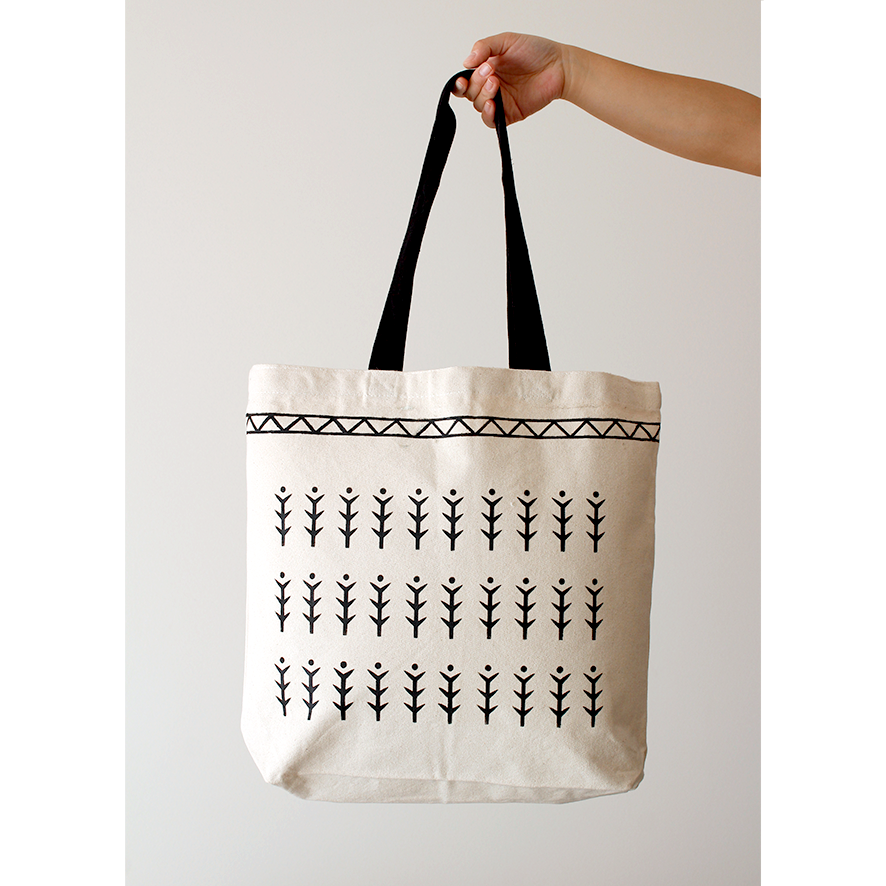 Black tribal pattern of fern trees hand-painted on a cotton natural beige canvas bag with black handles